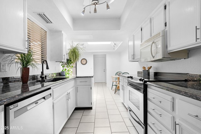 kitchen with a tray ceiling, visible vents, appliances with stainless steel finishes, light tile patterned flooring, and a sink