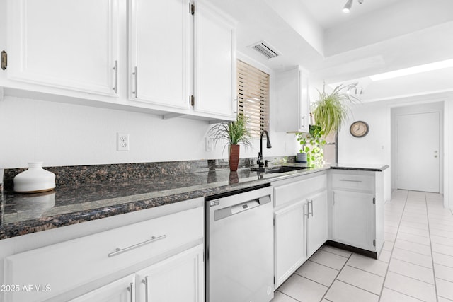 kitchen featuring stainless steel dishwasher, white cabinets, visible vents, dark stone countertops, and a sink