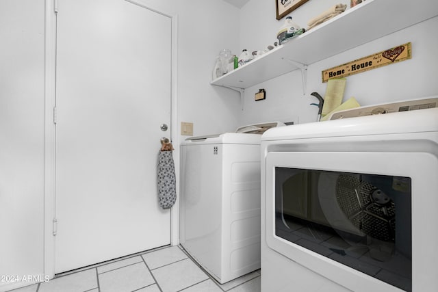 laundry room with laundry area, light tile patterned flooring, and separate washer and dryer