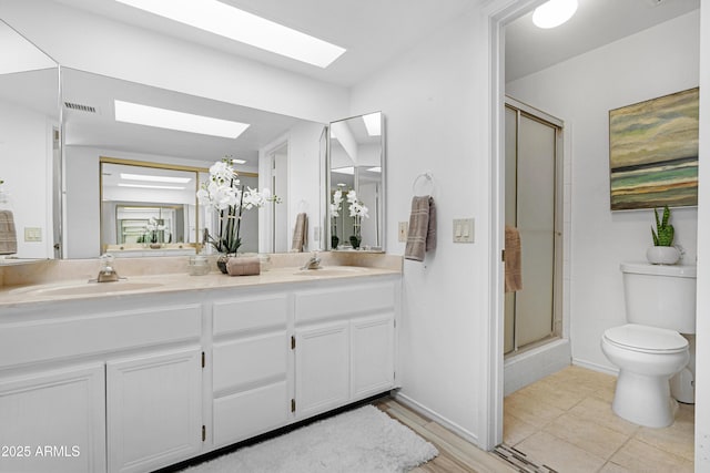 bathroom featuring visible vents, a sink, toilet, and a skylight
