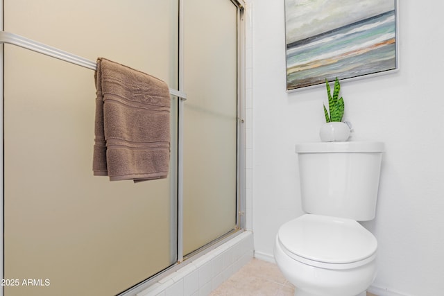 bathroom featuring toilet, tile patterned flooring, and a shower with door