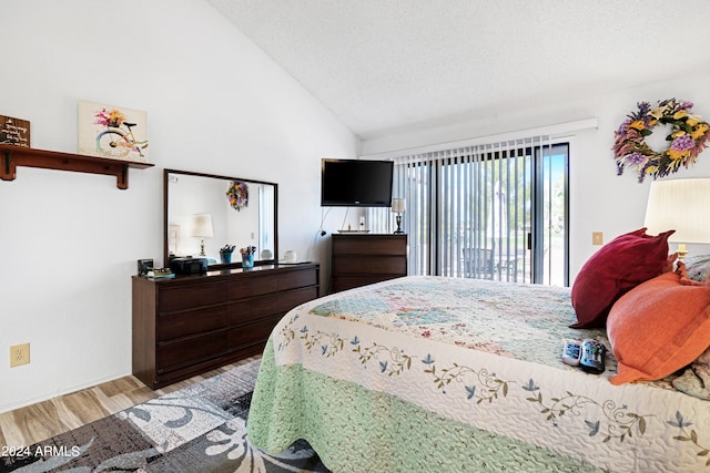 bedroom with access to exterior, high vaulted ceiling, light wood-type flooring, and a textured ceiling