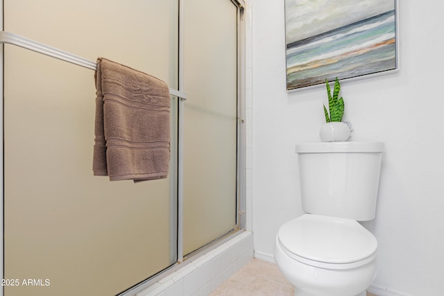 full bath featuring a shower with shower door, baseboards, toilet, and tile patterned floors