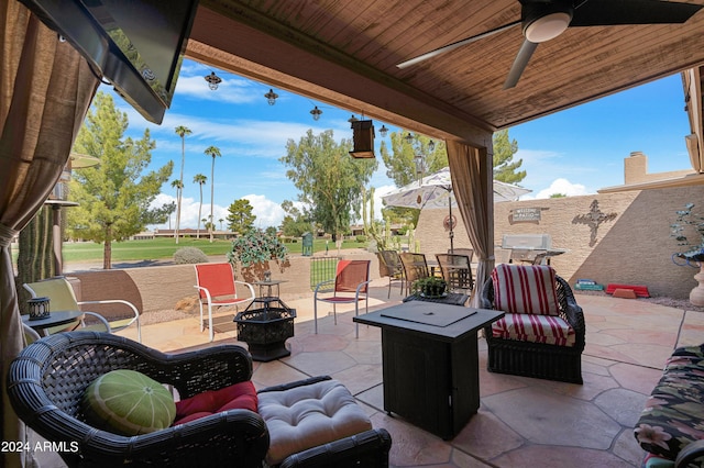 view of patio featuring a ceiling fan, an outdoor living space with a fire pit, and outdoor dining area