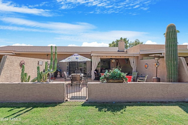 back of property with a patio, a gate, fence, and stucco siding