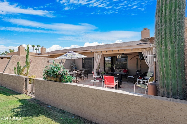 exterior space featuring a patio area, outdoor lounge area, fence, and a chimney