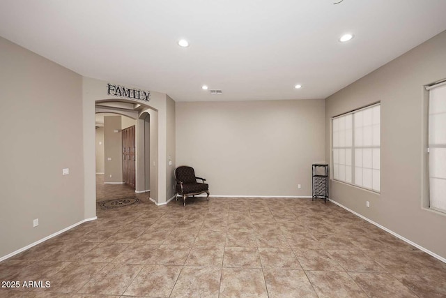 interior space with arched walkways, light tile patterned floors, recessed lighting, visible vents, and baseboards