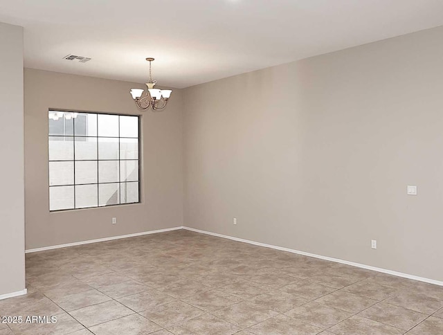 empty room with baseboards, light tile patterned floors, visible vents, and a notable chandelier