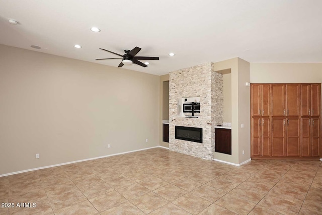 unfurnished living room with a large fireplace, ceiling fan, baseboards, and recessed lighting