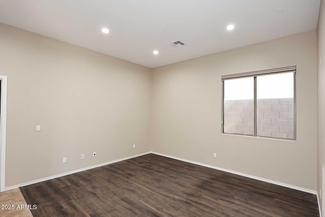 spare room featuring baseboards, visible vents, wood finished floors, and recessed lighting