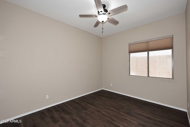 spare room with baseboards, dark wood finished floors, and a ceiling fan