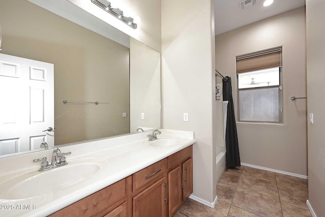 bathroom featuring double vanity, visible vents, a sink, and tile patterned floors