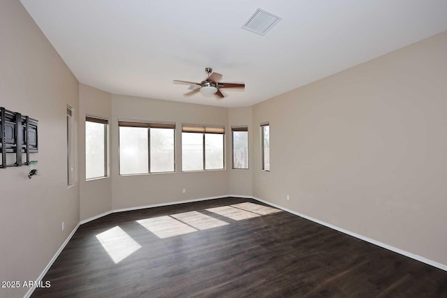 spare room with visible vents, ceiling fan, baseboards, and wood finished floors