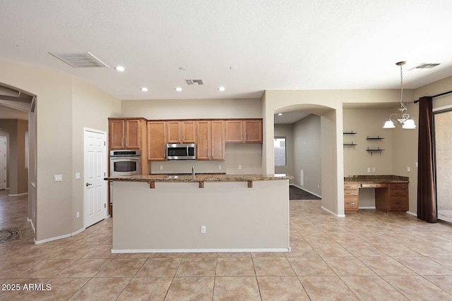 kitchen with appliances with stainless steel finishes, arched walkways, and visible vents