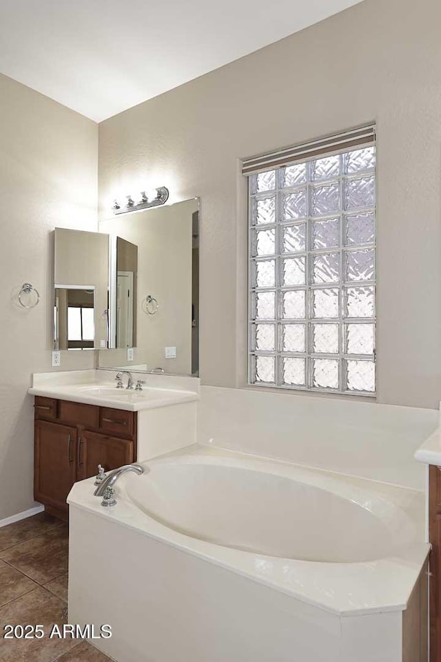 bathroom with a bath, tile patterned flooring, and vanity