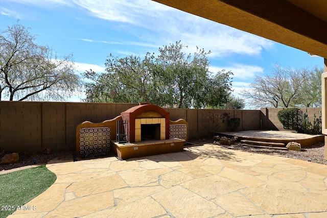 view of patio / terrace with a tiled fireplace and a fenced backyard