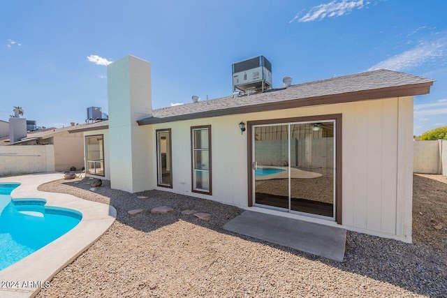 rear view of property with a fenced in pool, a patio area, and central AC