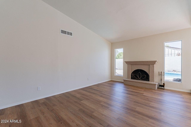 unfurnished living room featuring vaulted ceiling and hardwood / wood-style floors