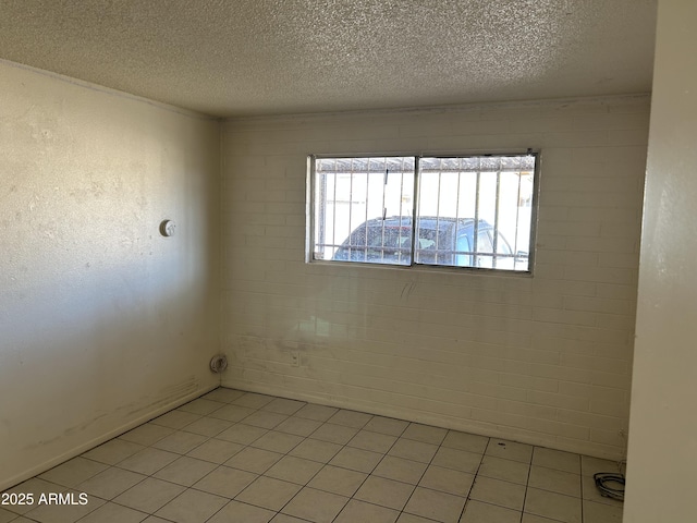 unfurnished room with light tile patterned floors and a textured ceiling