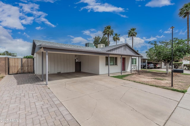 9609 N 44th Ave, Glendale, AZ 85302 - single story home featuring a shingled roof, board and batten siding, an attached carport, a gate, and driveway