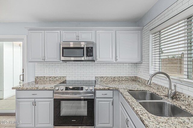 9609 N 44th Ave, Glendale, AZ 85302 - kitchen with backsplash, stainless steel appliances, light stone counters, and a sink