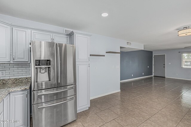 9609 N 44th Ave, Glendale, AZ 85302 - kitchen featuring stainless steel fridge with ice dispenser, baseboards, tasteful backsplash, light stone counters, and light tile patterned floors