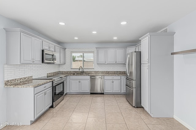 9609 N 44th Ave, Glendale, AZ 85302 - kitchen with decorative backsplash, light stone countertops, a sink, light tile patterned floors, and stainless steel appliances