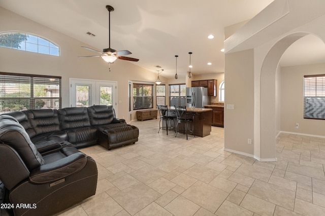 tiled living room featuring high vaulted ceiling, french doors, and ceiling fan