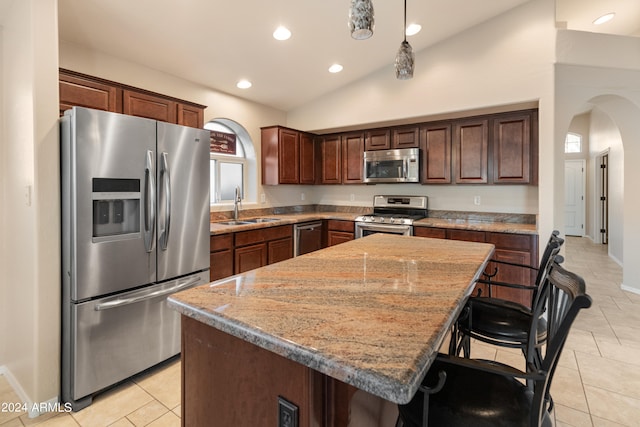 kitchen featuring appliances with stainless steel finishes, sink, a kitchen island, and light tile flooring