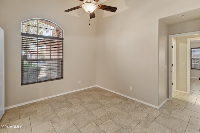 tiled spare room featuring ceiling fan