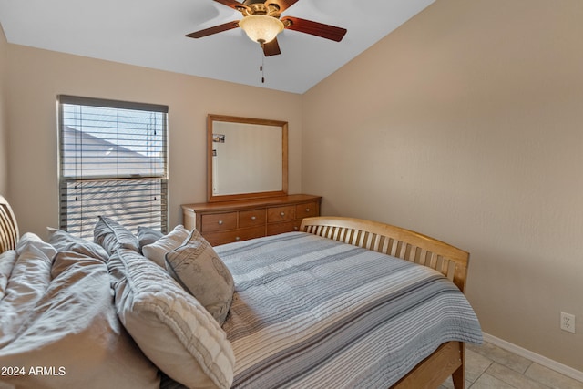 bedroom with lofted ceiling, ceiling fan, and light tile flooring