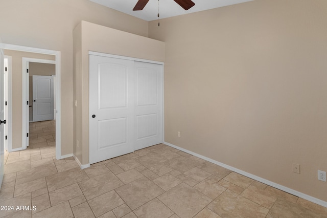 unfurnished bedroom with ceiling fan, a closet, and light tile floors