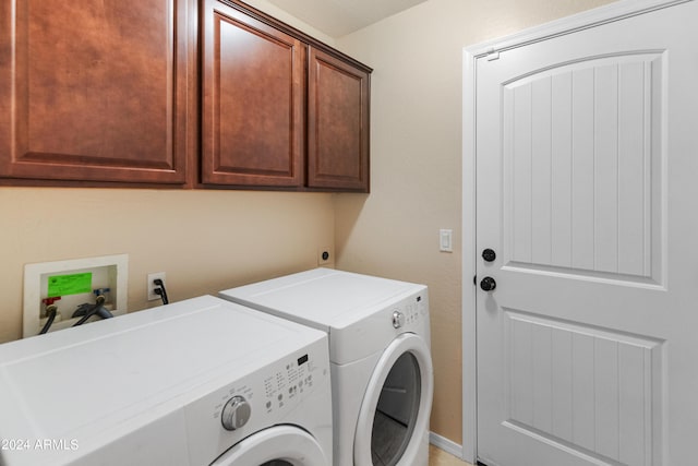 washroom featuring cabinets, hookup for a washing machine, and washer and dryer