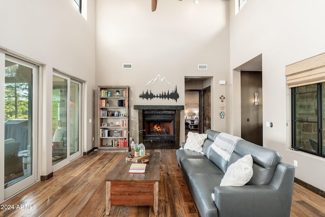 living room with hardwood / wood-style floors and a towering ceiling