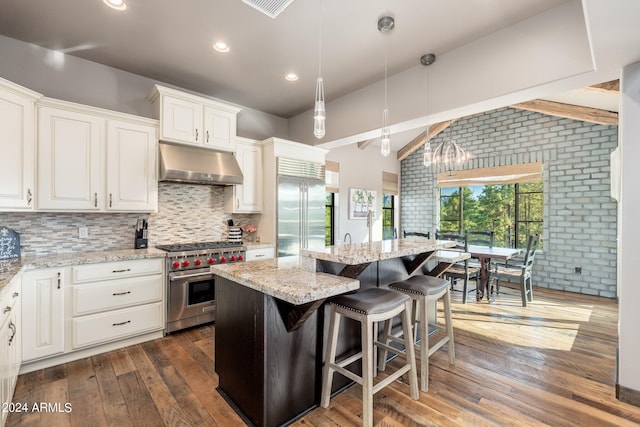 kitchen featuring dark hardwood / wood-style flooring, high quality appliances, a center island, and extractor fan