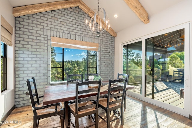 dining area with a notable chandelier, brick wall, light hardwood / wood-style flooring, and vaulted ceiling with beams