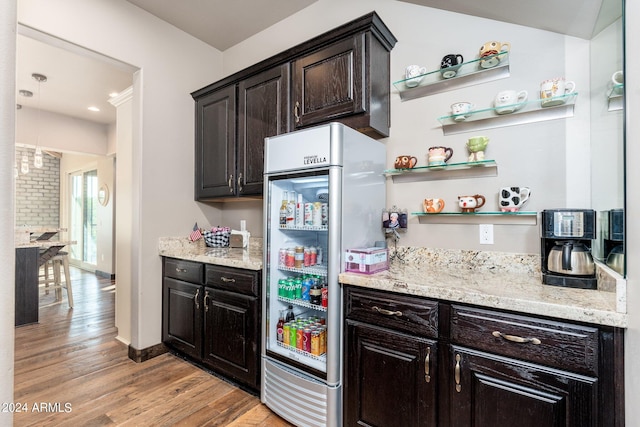 kitchen with light stone countertops, light hardwood / wood-style floors, dark brown cabinets, and high end fridge