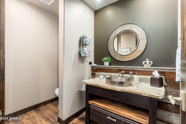 bathroom with vanity, wood-type flooring, and toilet