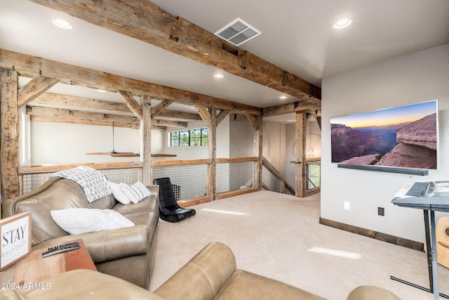 carpeted home theater room with beamed ceiling