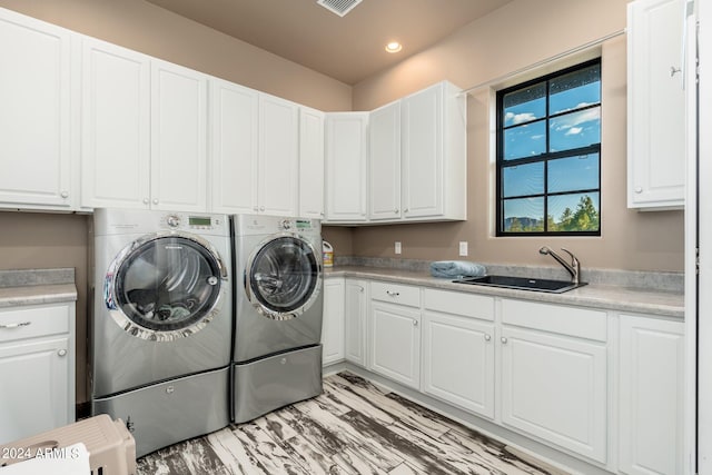 laundry room with cabinets, sink, and washing machine and clothes dryer