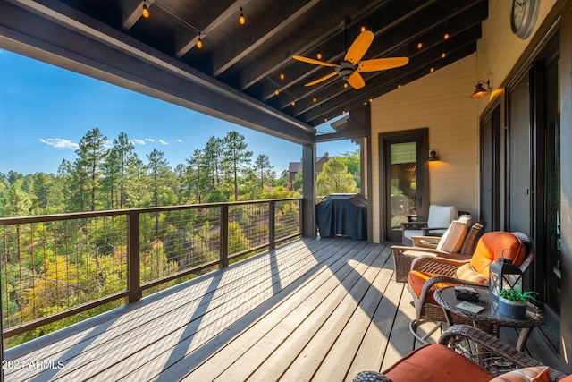 wooden terrace featuring grilling area and ceiling fan