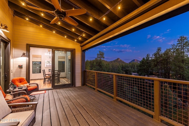 deck at dusk featuring ceiling fan