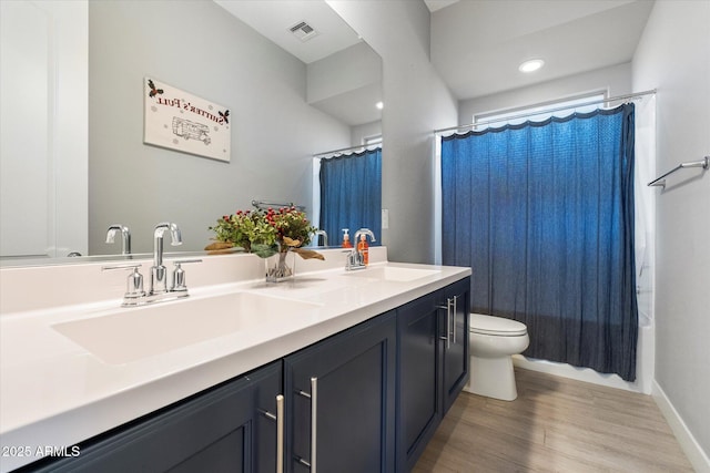 full bathroom featuring vanity, hardwood / wood-style floors, shower / bath combination with curtain, and toilet