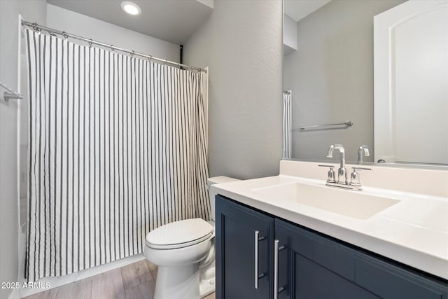 bathroom with vanity, hardwood / wood-style flooring, and toilet