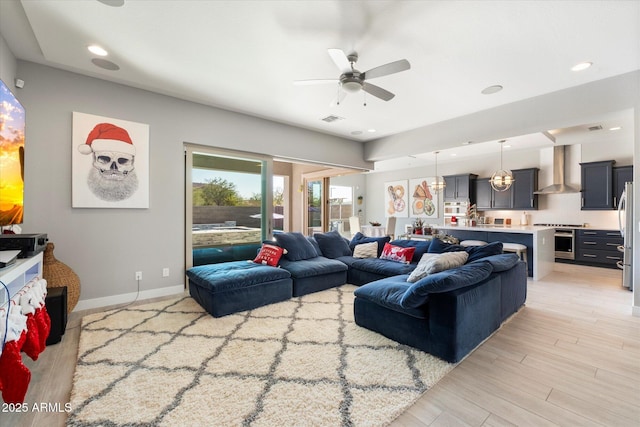 living room with ceiling fan and light wood-type flooring