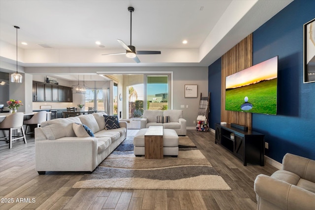 living room featuring ceiling fan and dark hardwood / wood-style flooring