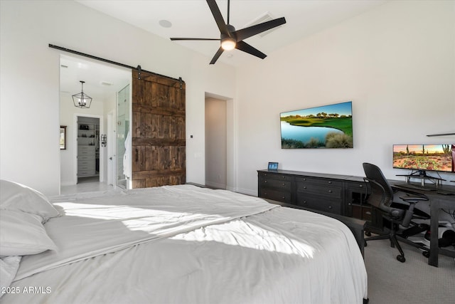 carpeted bedroom featuring a barn door and ceiling fan