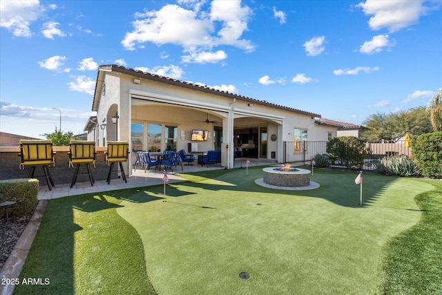 back of property with a patio and a fire pit