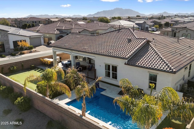 exterior space featuring a fenced in pool, a mountain view, and a patio area