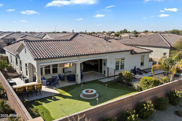 back of property with an outdoor fire pit and a patio